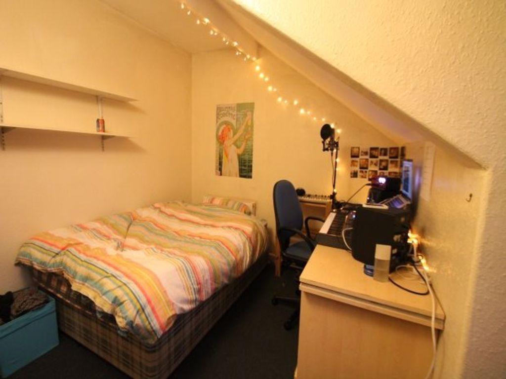 A cozy single bedroom featuring a neatly made b...