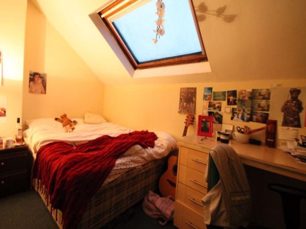 A cozy, well-lit bedroom featuring a skylight w...