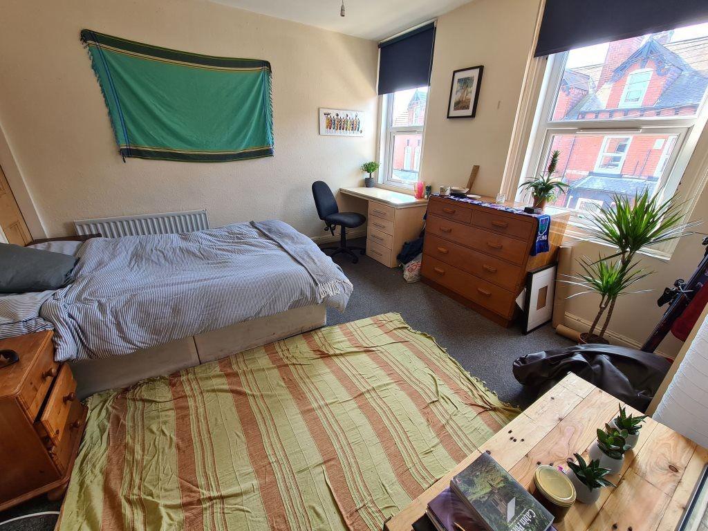 A bright and inviting bedroom featuring a comfo...