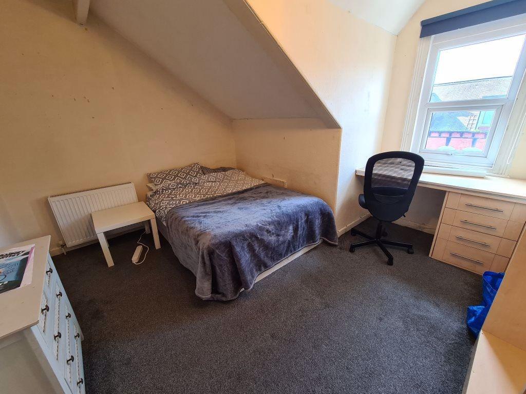 A cozy bedroom featuring a double bed, a desk a...