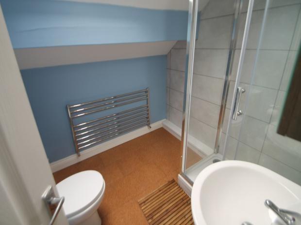 A modern bathroom featuring a glass-enclosed sh...