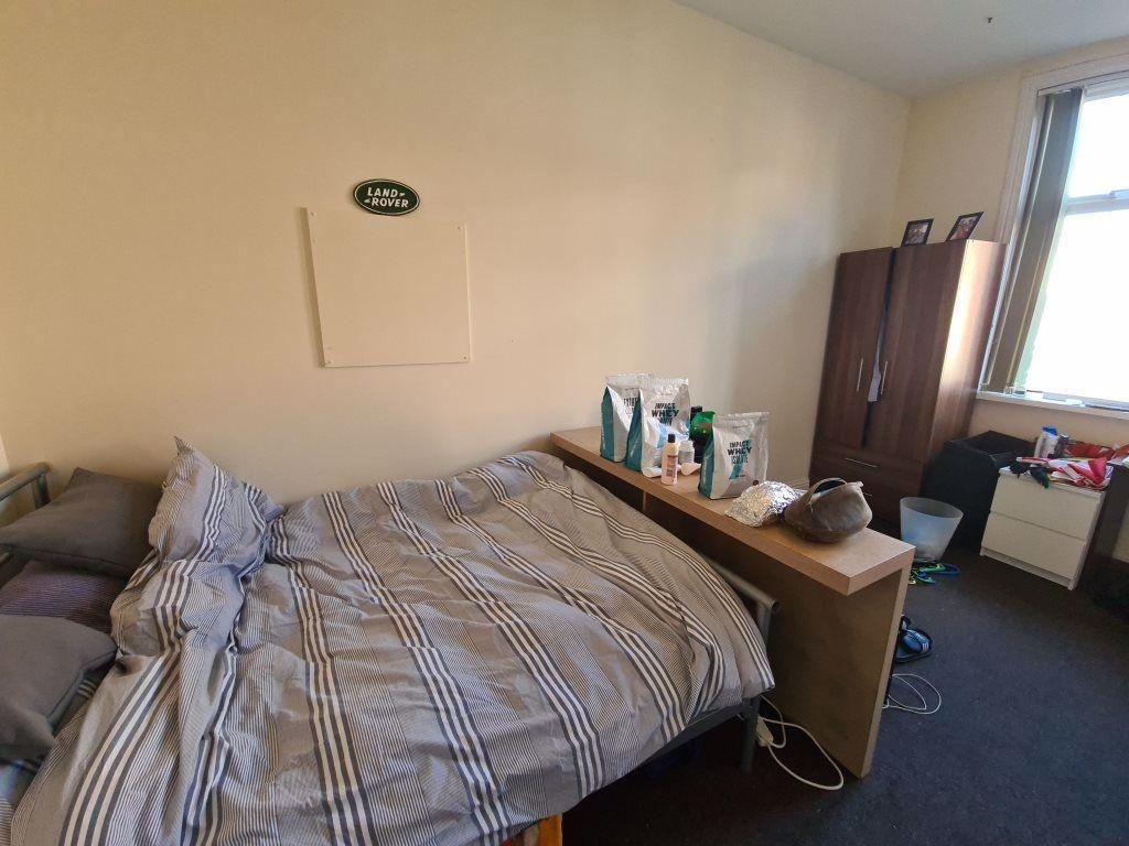 A comfortably furnished bedroom featuring a dou...