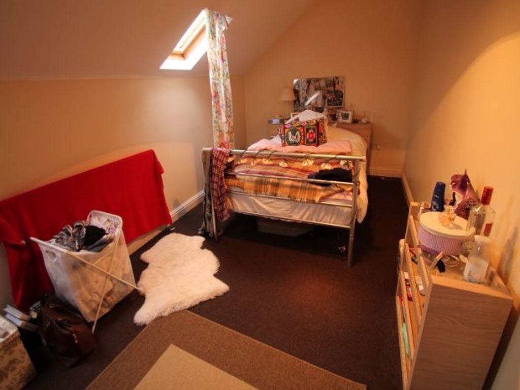 A cozy bedroom featuring a single bed with colo...