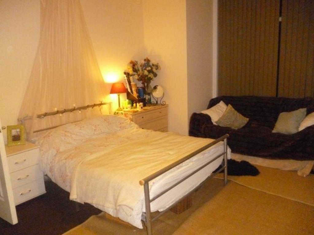 A cozy bedroom featuring a double bed with a si...