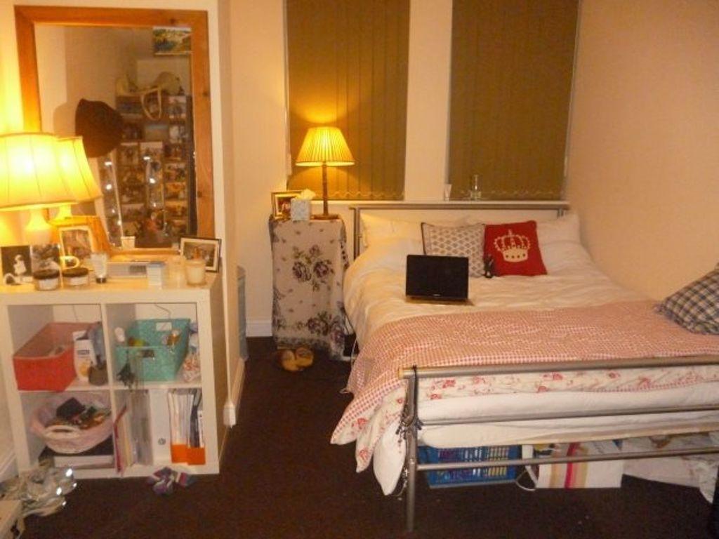 A cozy bedroom with a neatly made bed, bedside ...