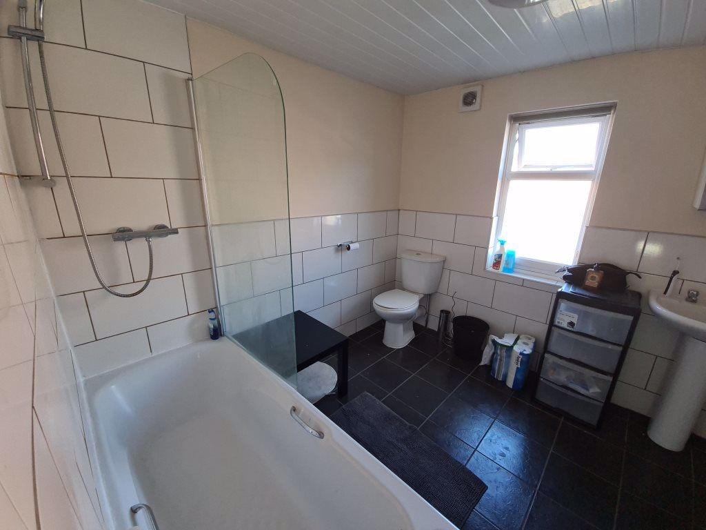 A spacious bathroom featuring a bathtub, large ...