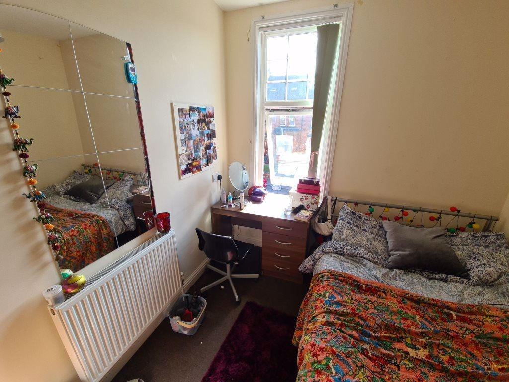 A cozy bedroom featuring a double bed with patt...