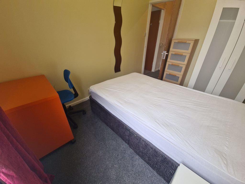 A cozy single bedroom featuring a comfortable b...