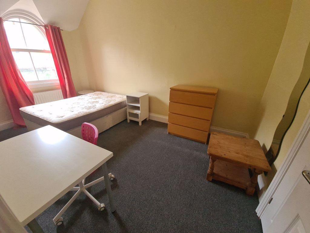 A modest single bedroom with a window allowing ...