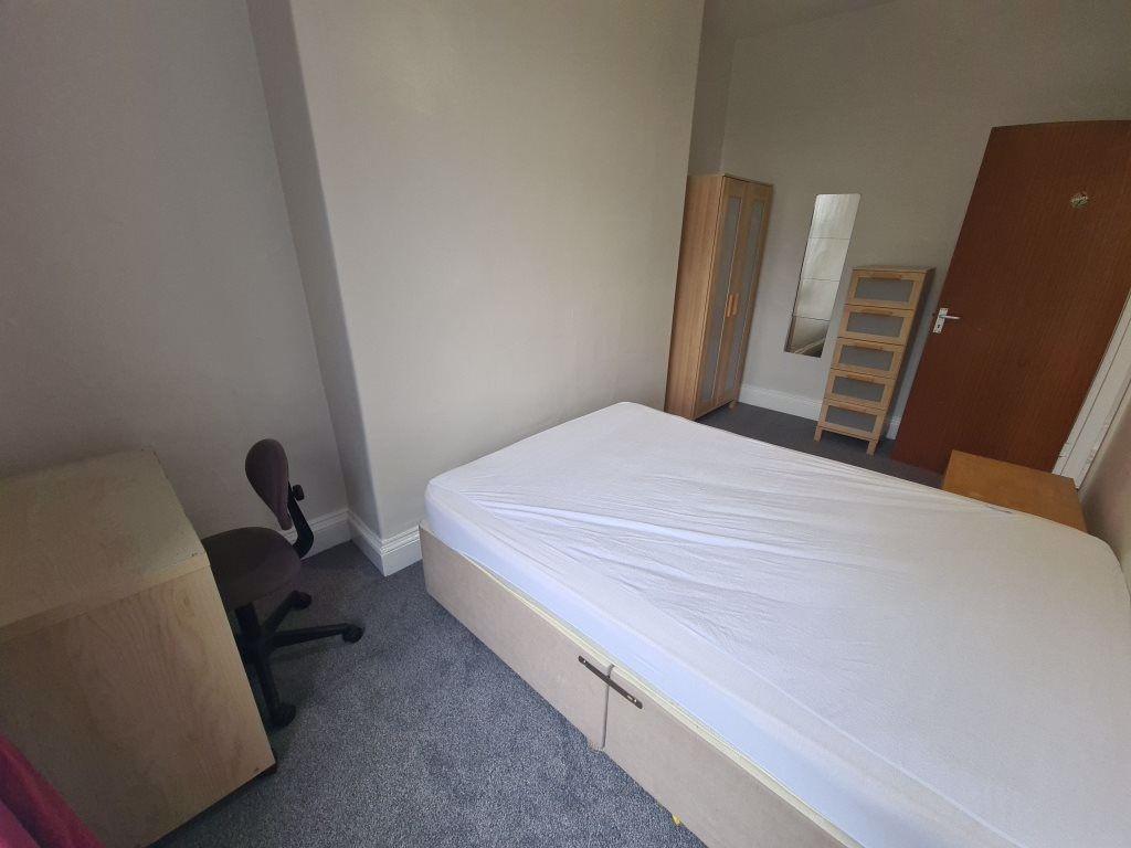 A simple single bedroom with basic furnishings ...