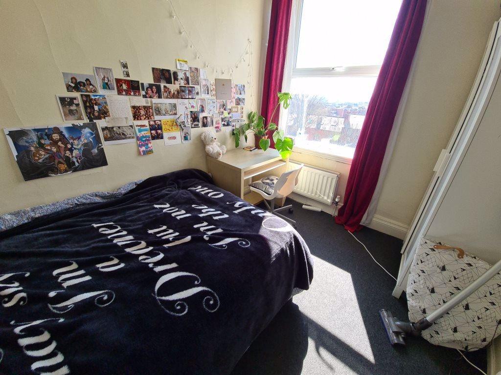 A cozy bedroom featuring a neatly made bed with...