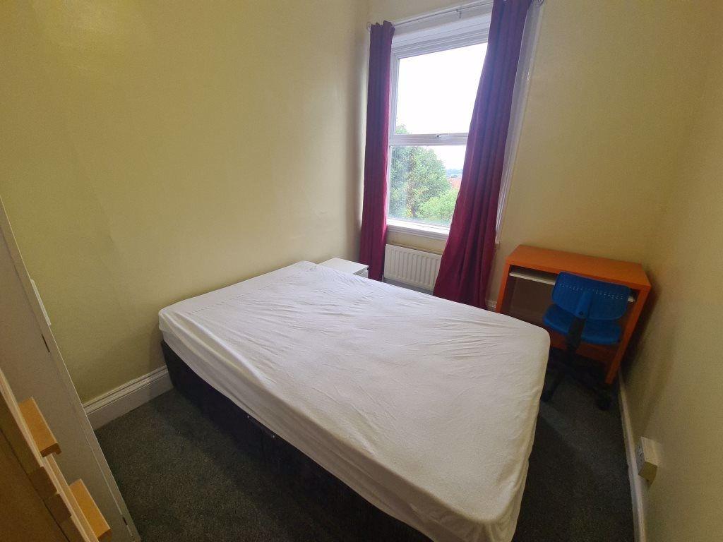 A cozy bedroom featuring a single bed positione...