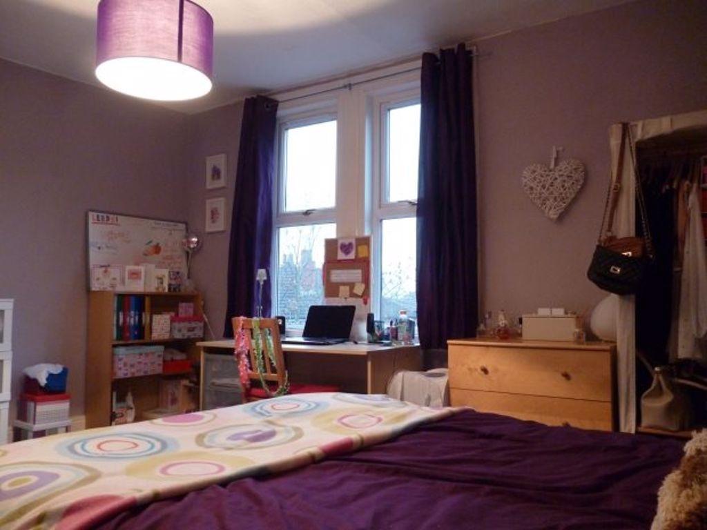 A cozy bedroom featuring a neatly made bed, a w...