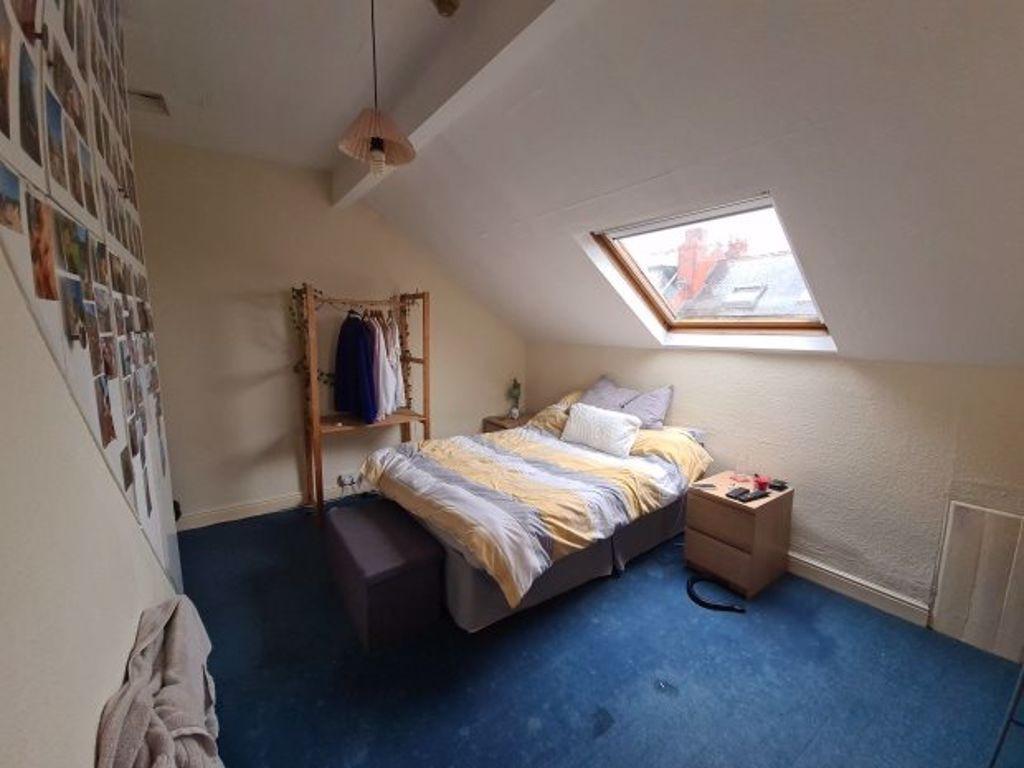 A cozy single bedroom featuring a bed under a s...