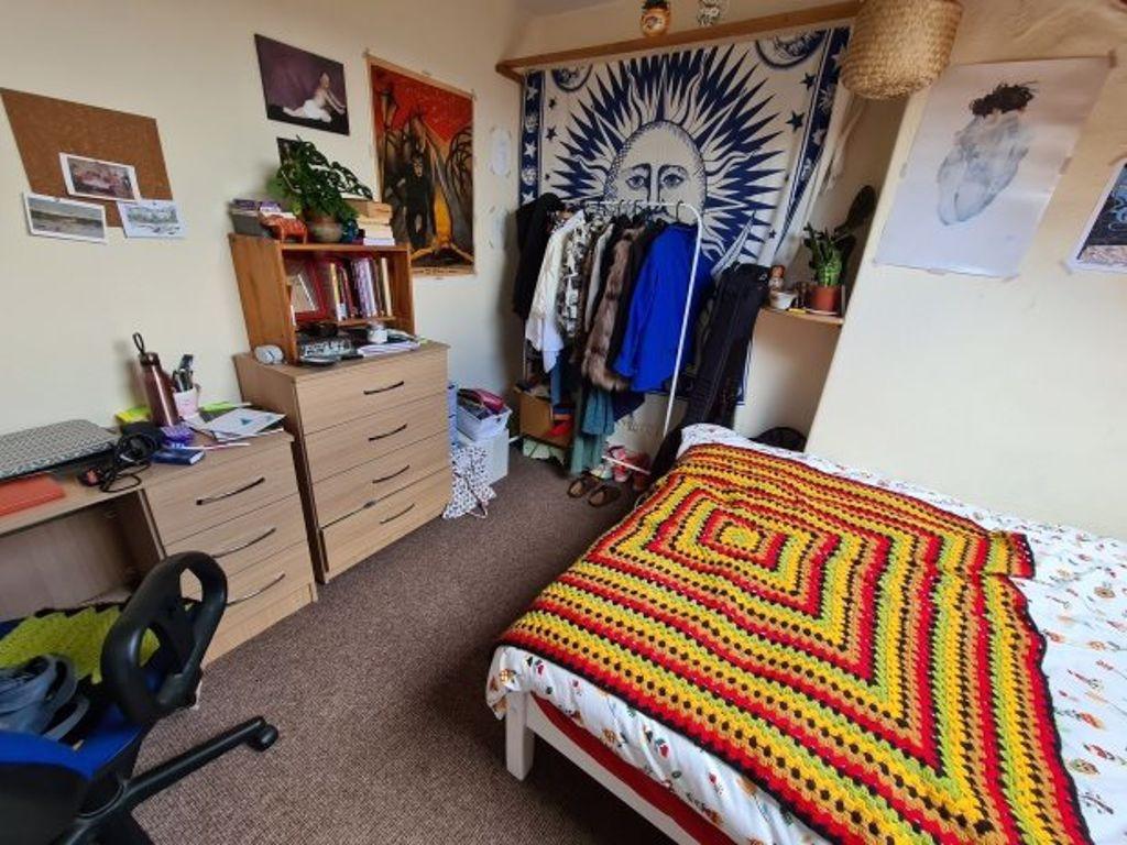 Cozy bedroom featuring a vibrant crocheted blan...