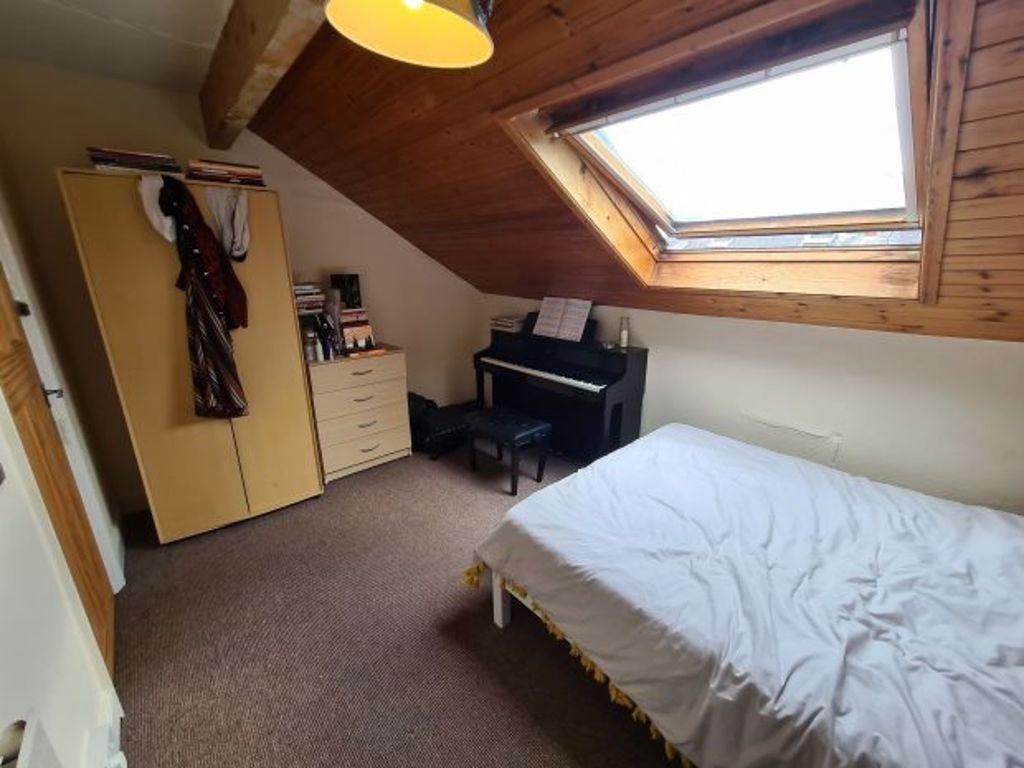 A cozy double bedroom featuring a large skyligh...