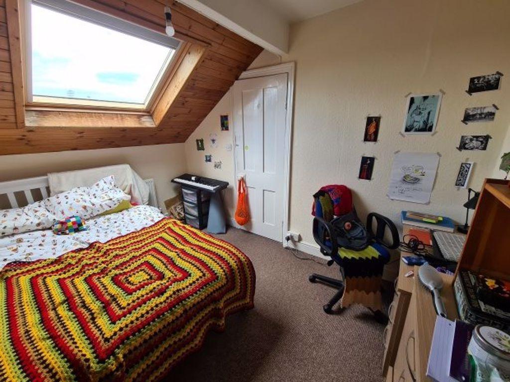 A cozy single bedroom featuring a comfortable b...
