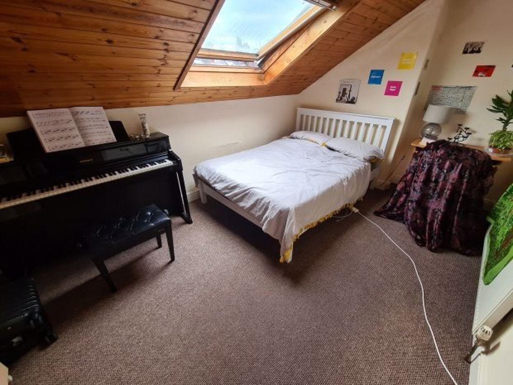 A cozy attic bedroom featuring a comfortable si...