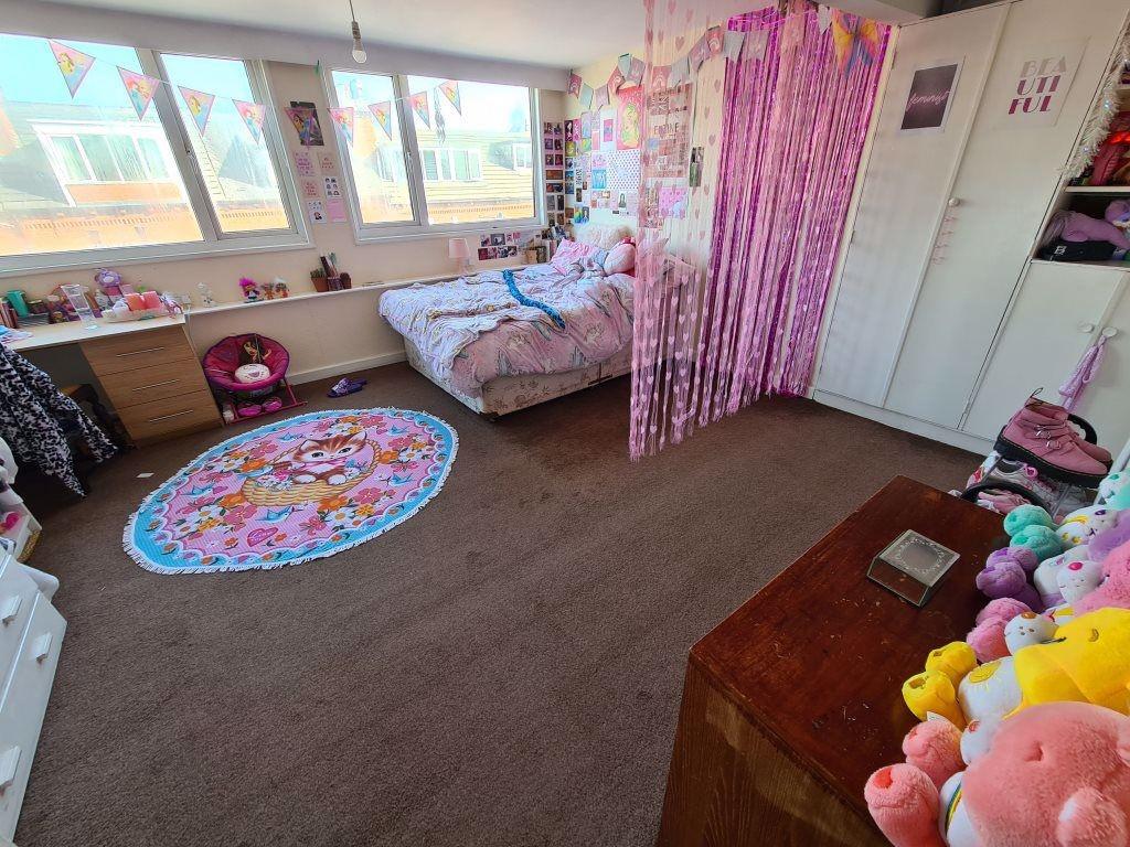 A cozy bedroom featuring a large bed with ample...