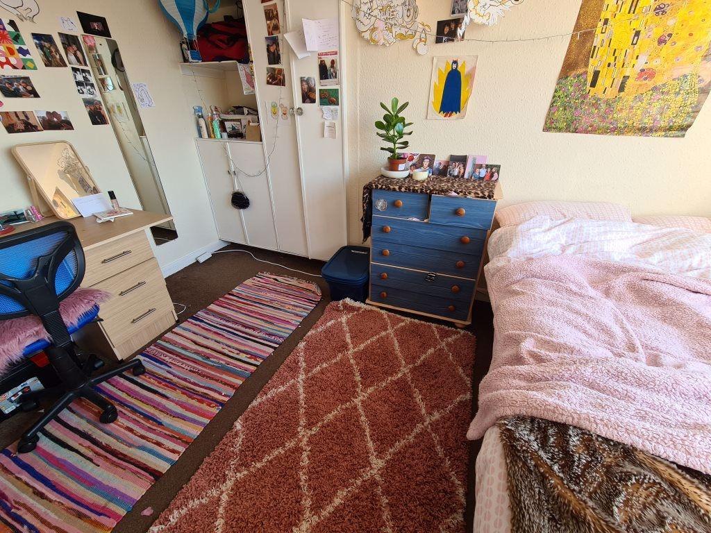 A cozy bedroom featuring a comfortable bed, a d...