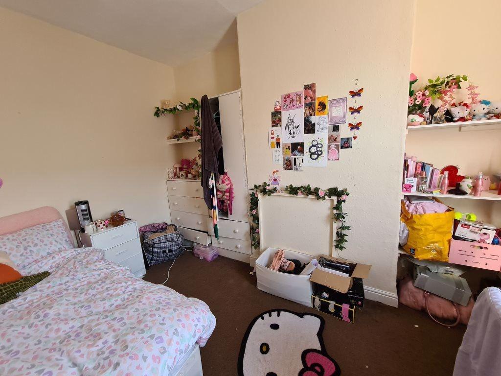 A cozy bedroom featuring a neatly made bed with...