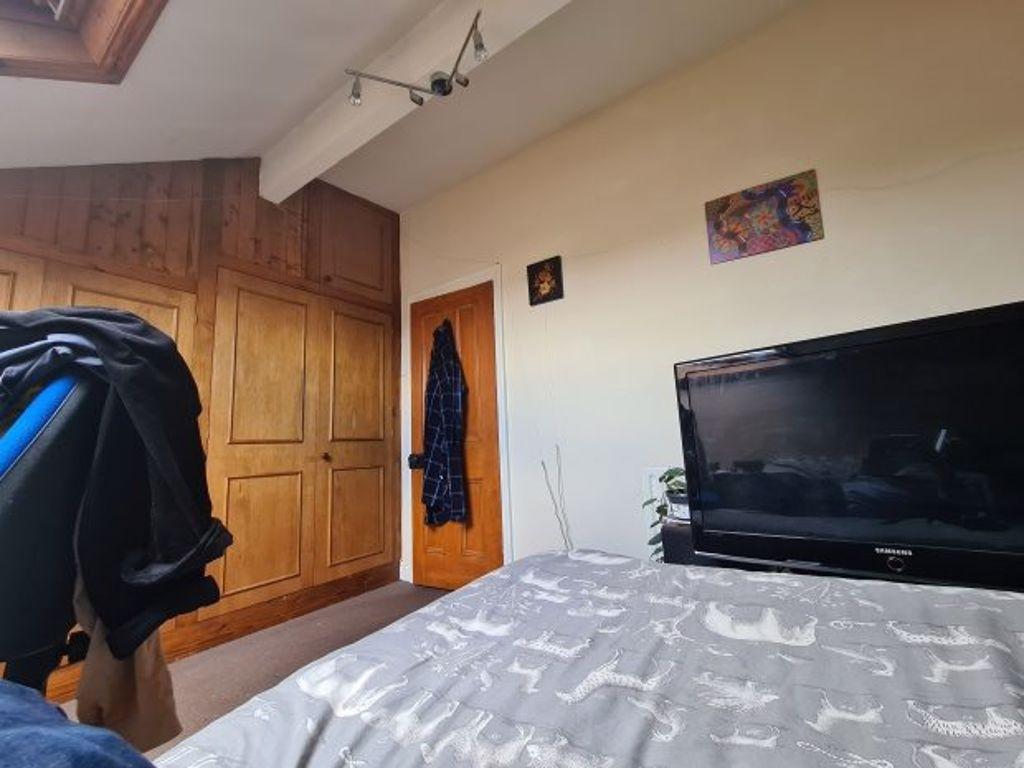A cozy bedroom featuring a comfortable bed, a T...