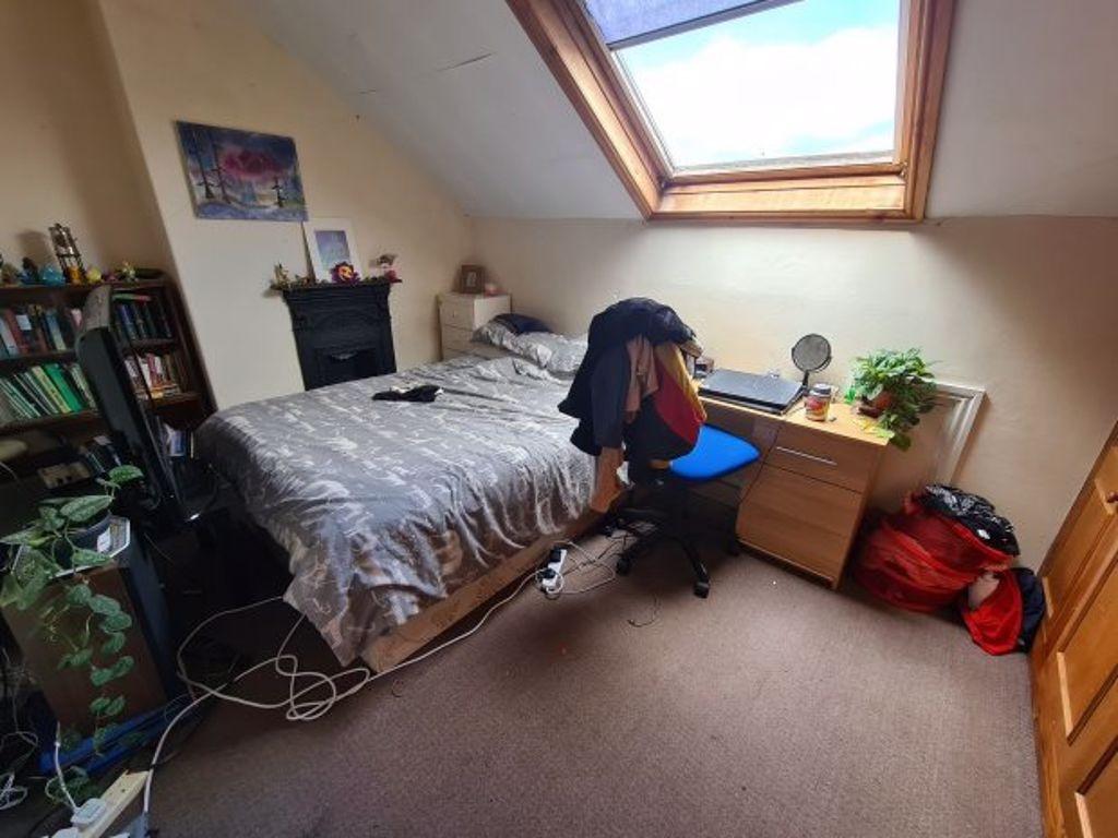 A cozy single bedroom with a comfortable bed, a...