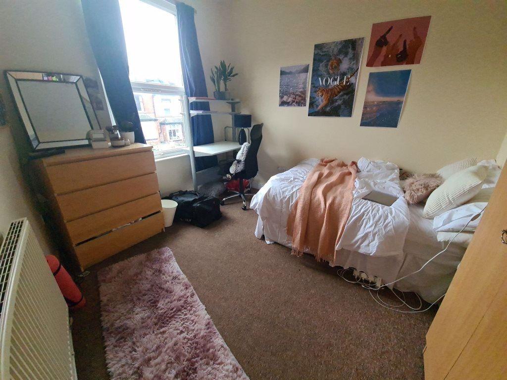 A cozy bedroom featuring a double bed, a window...