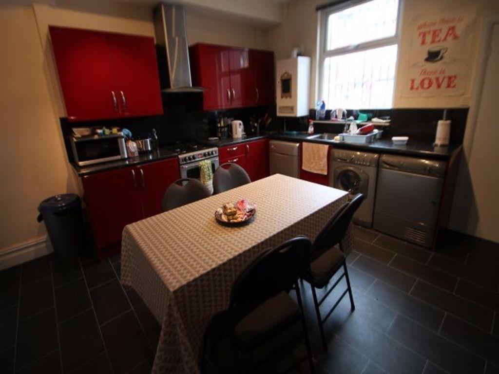 A contemporary kitchen featuring modern red cab...
