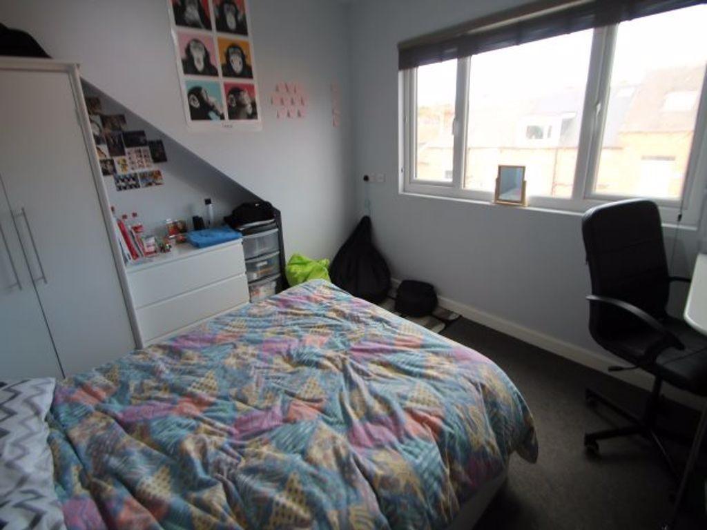 A well-lit, inviting master bedroom featuring a...