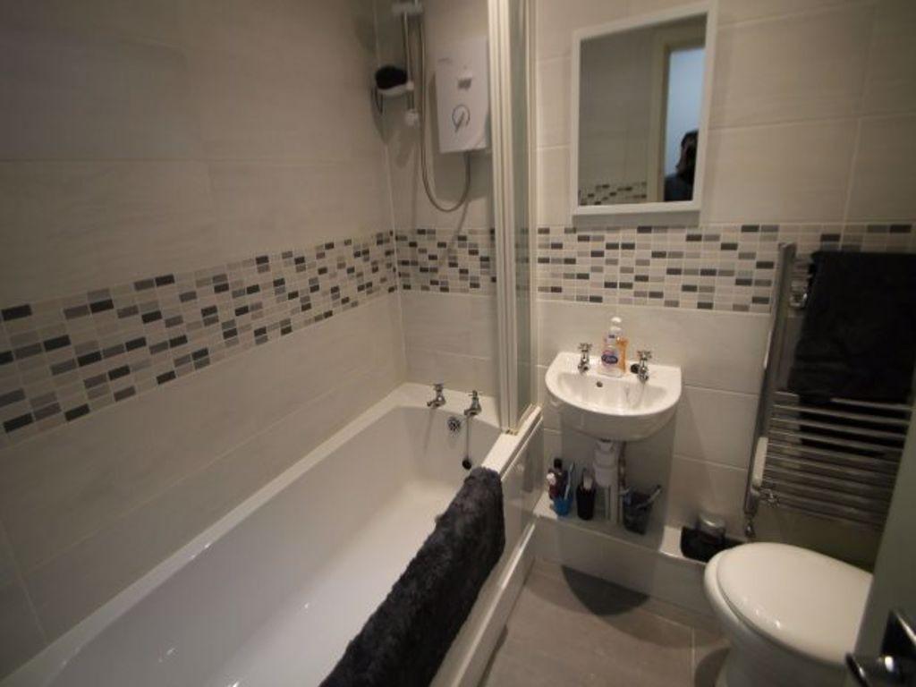 A well-maintained bathroom featuring a bathtub ...
