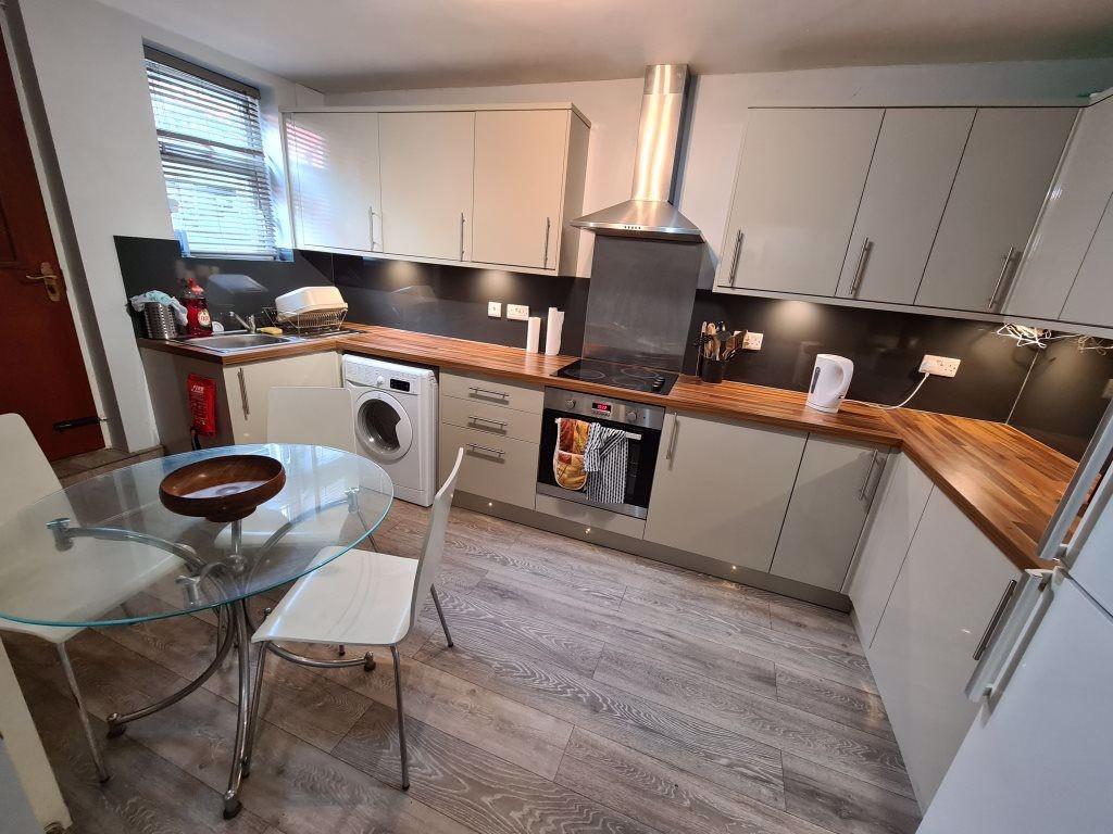 A modern, well-lit kitchen featuring white cabi...