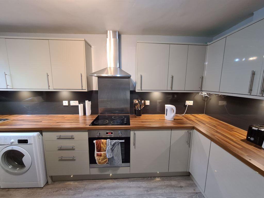 A modern, well-lit kitchen featuring sleek whit...