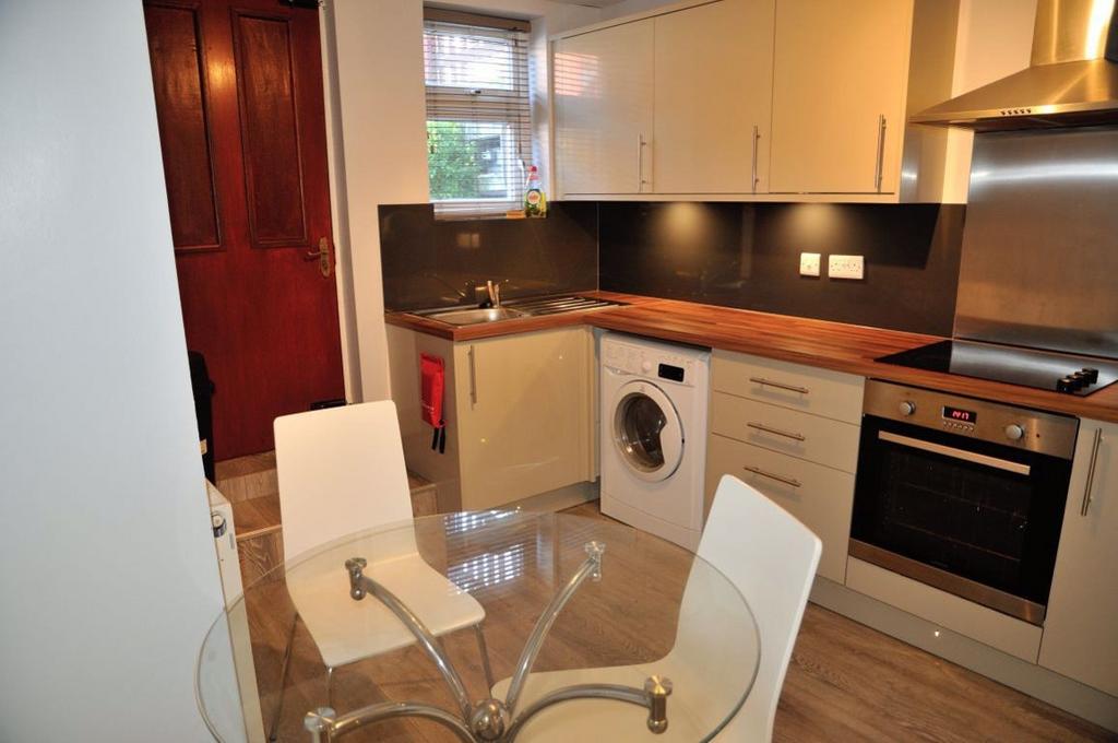 A modern, well-lit kitchen featuring white cabi...