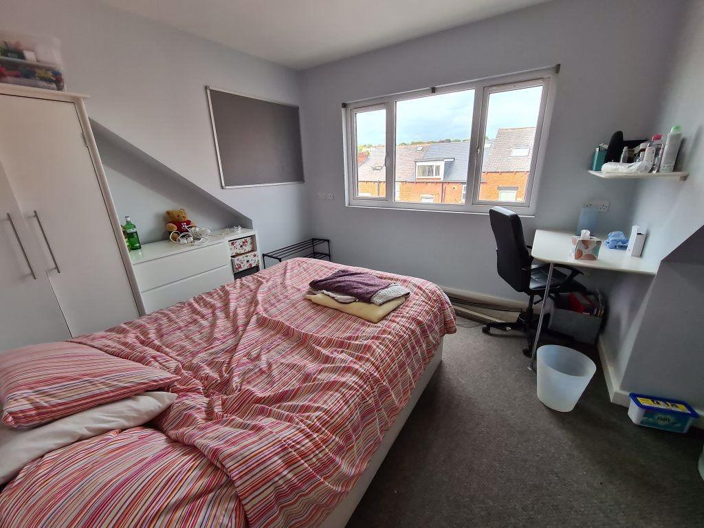 A cozy student bedroom featuring a comfortable ...