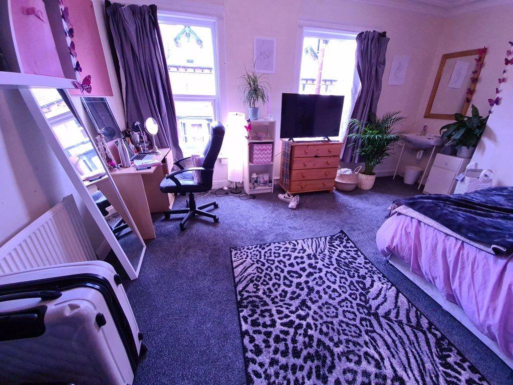 A spacious and well-lit master bedroom featurin...