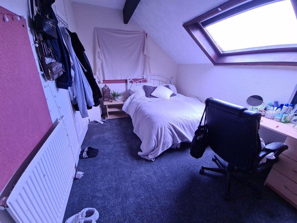 A cozy bedroom featuring a neatly made double b...