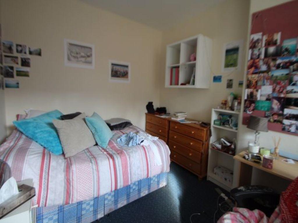 A cozy bedroom featuring a double bed dressed w...