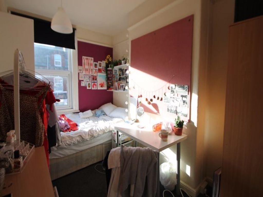 A cozy bedroom with a single bed placed near a ...
