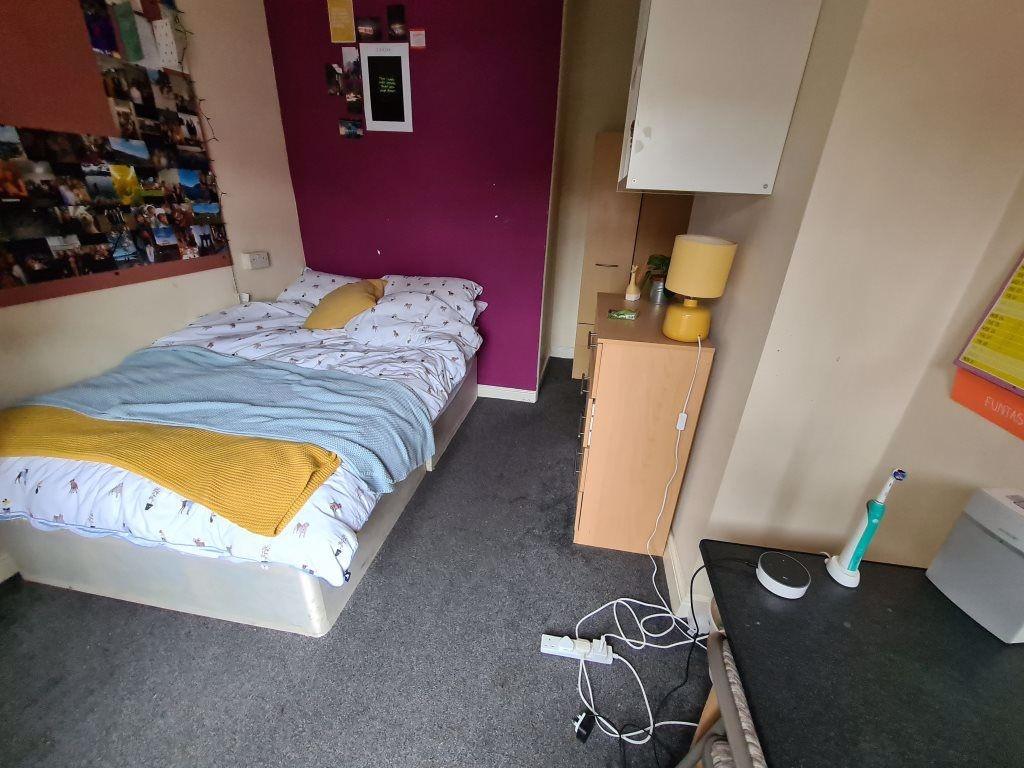 A cozy bedroom featuring a neatly made bed with...