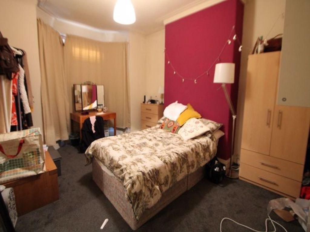 A cozy bedroom featuring a double bed with a pl...