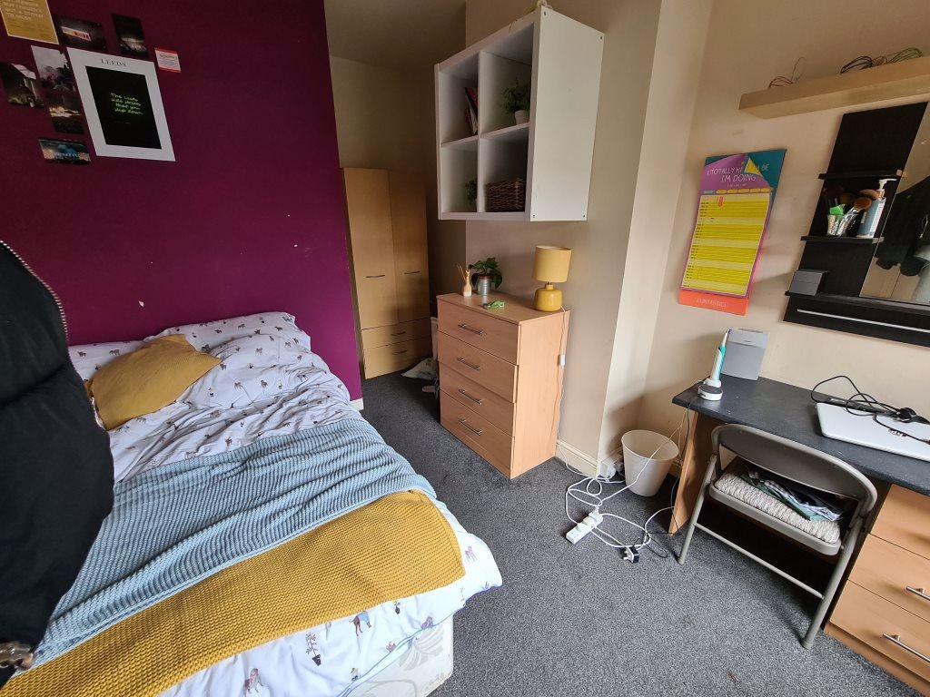 A cozy bedroom featuring a bed with yellow and ...