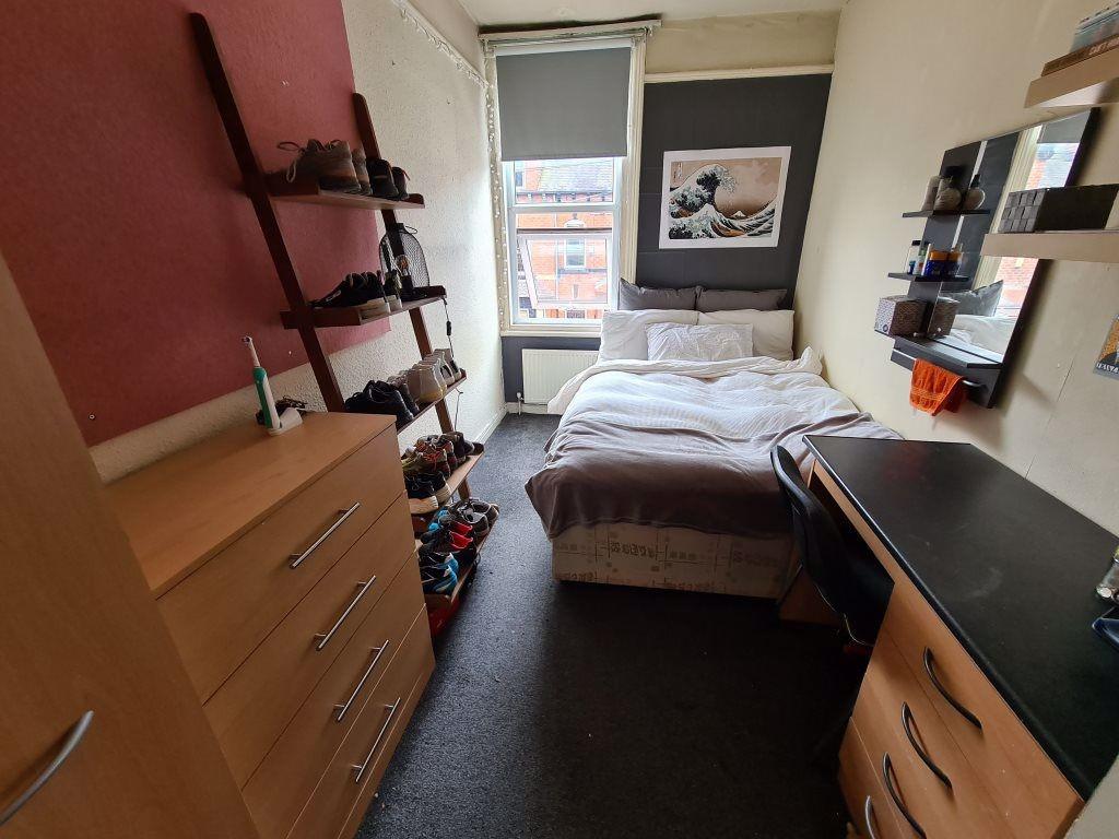 A cozy bedroom with a single bed, a desk, and s...