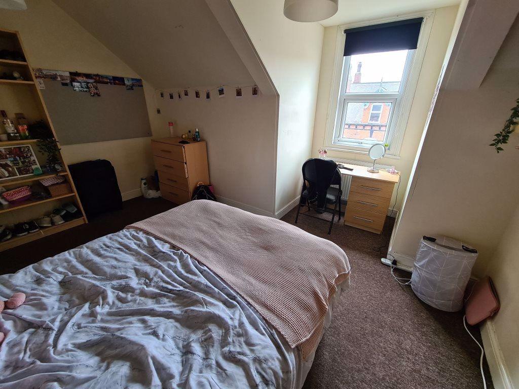 A spacious and inviting bedroom with a large be...