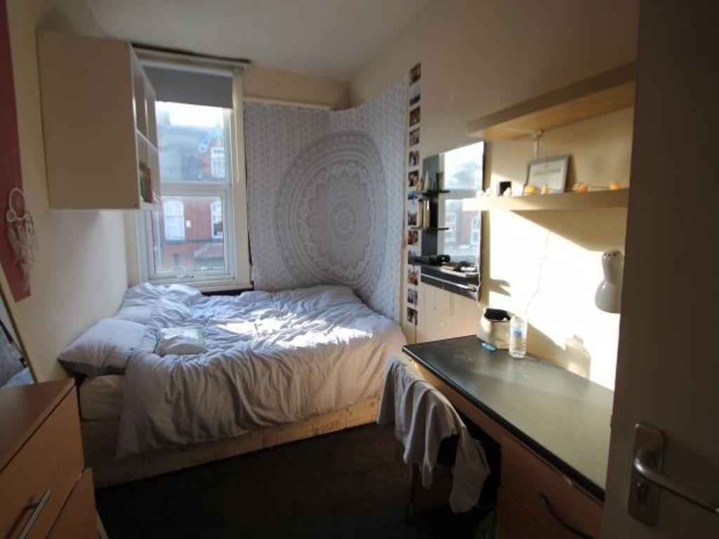 A cozy bedroom featuring a neatly made bed, a l...