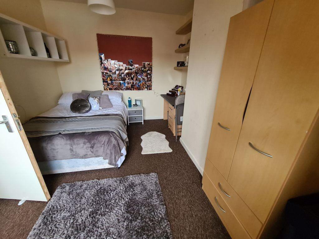 A cozy bedroom featuring a double bed, fitted w...