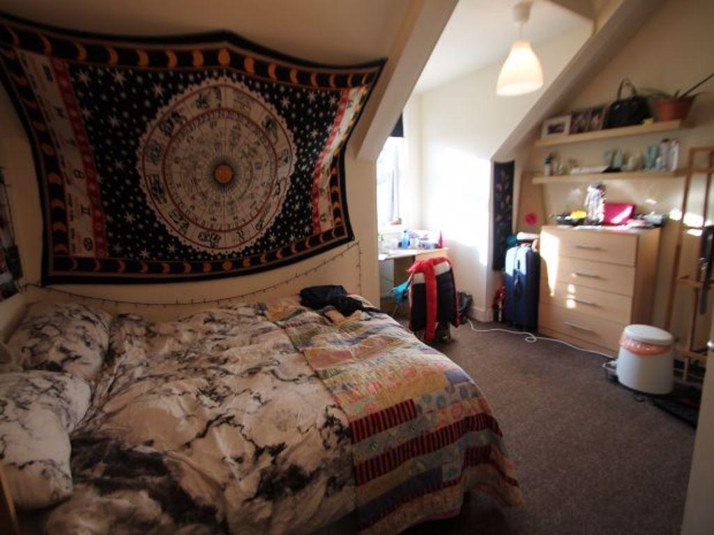 A cozy bedroom featuring a double bed, a window...