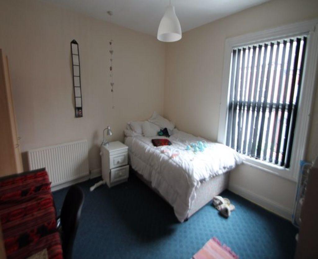 A bright and cozy bedroom featuring a comfortab...