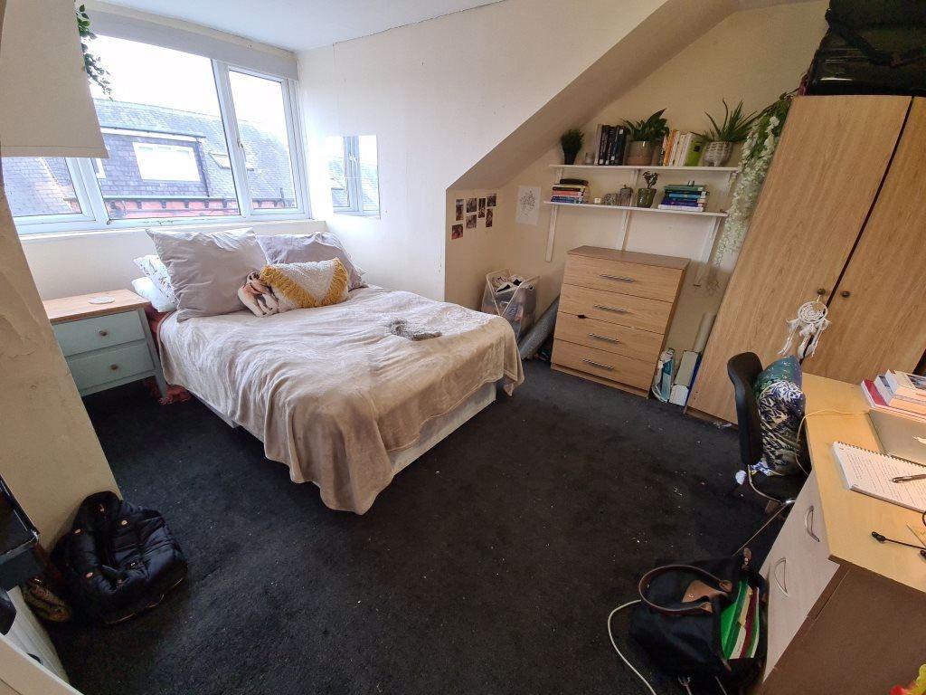 A cozy bedroom featuring a double bed with a be...