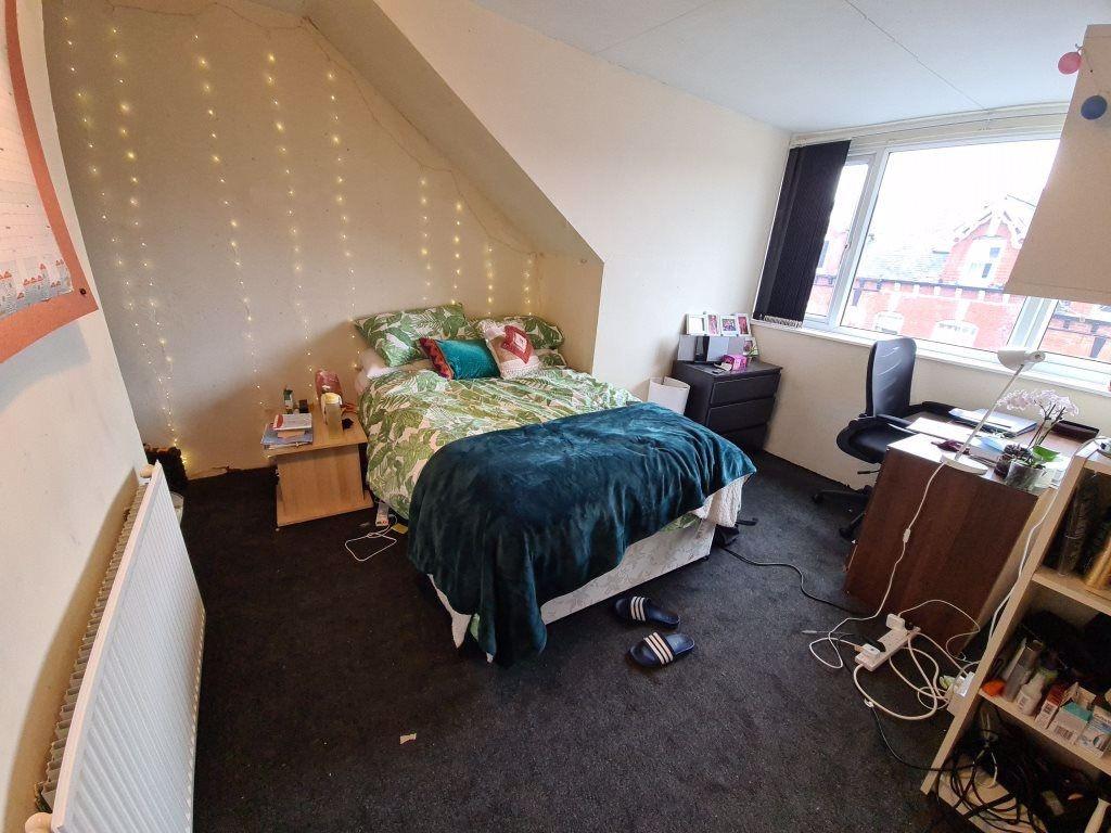 A cozy bedroom featuring a double bed with colo...